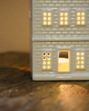 Load image into Gallery viewer, Model of a building with illuminated windows on a wooden surface
